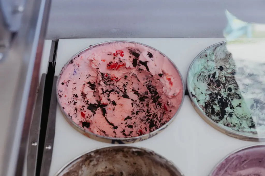 Pink ice cream with chocolate cookie pieces and cherry chunks displayed in a dipping cabinet at Buoy 18.