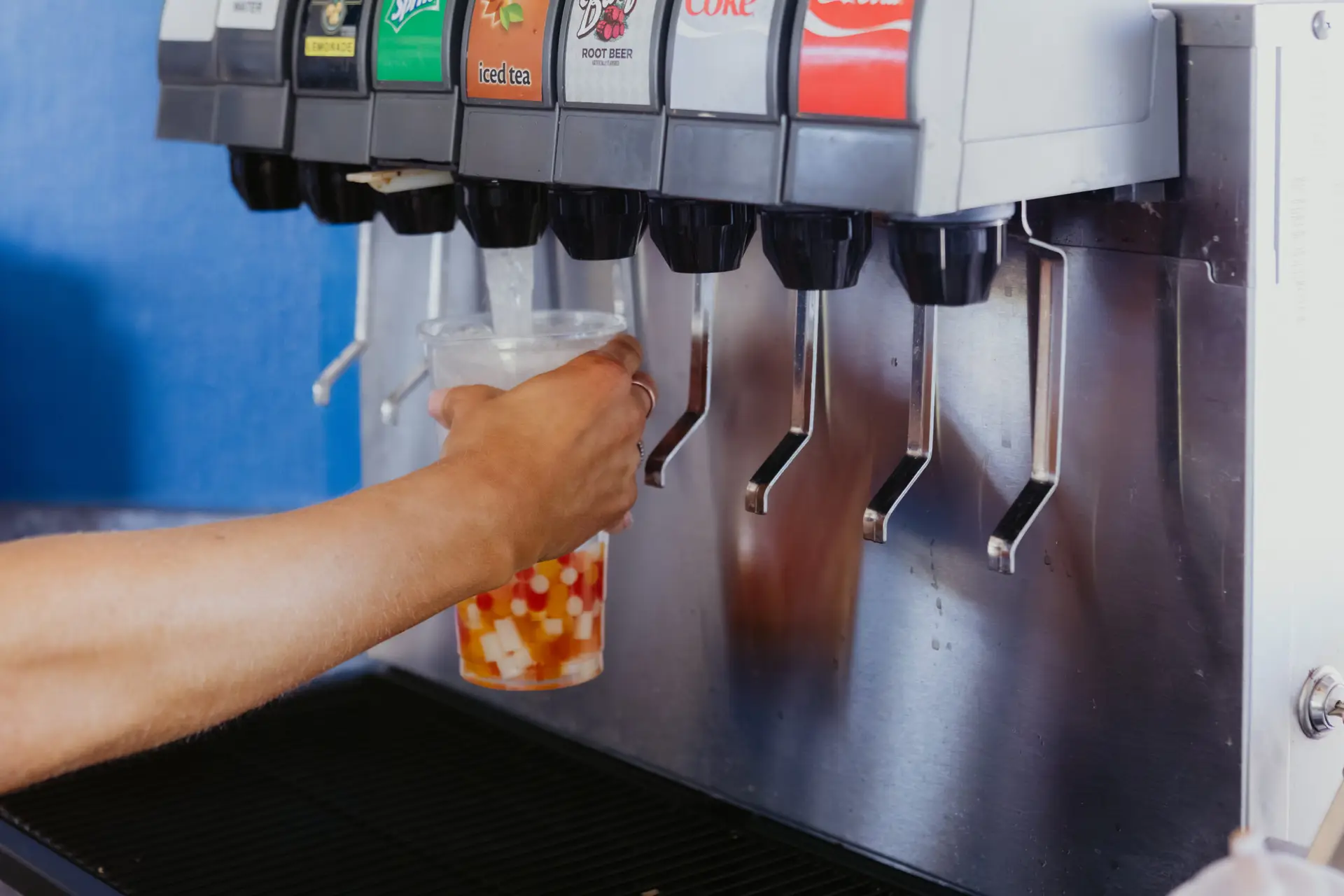 Bubble tea being prepared at Buoy 18, with colorful popping boba and soda being dispensed into a clear cup.