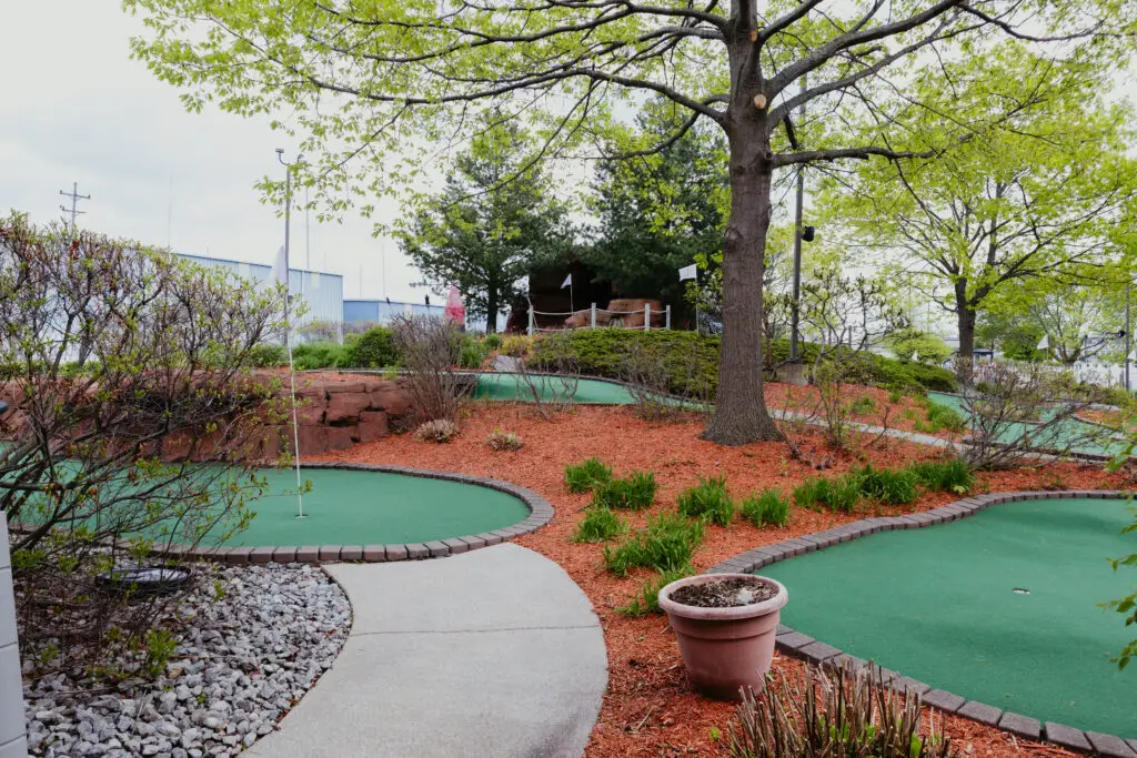 Beautifully landscaped mini golf course at Buoy 18 in Bay City, Michigan, featuring winding greens, mature trees, and scenic pathways.