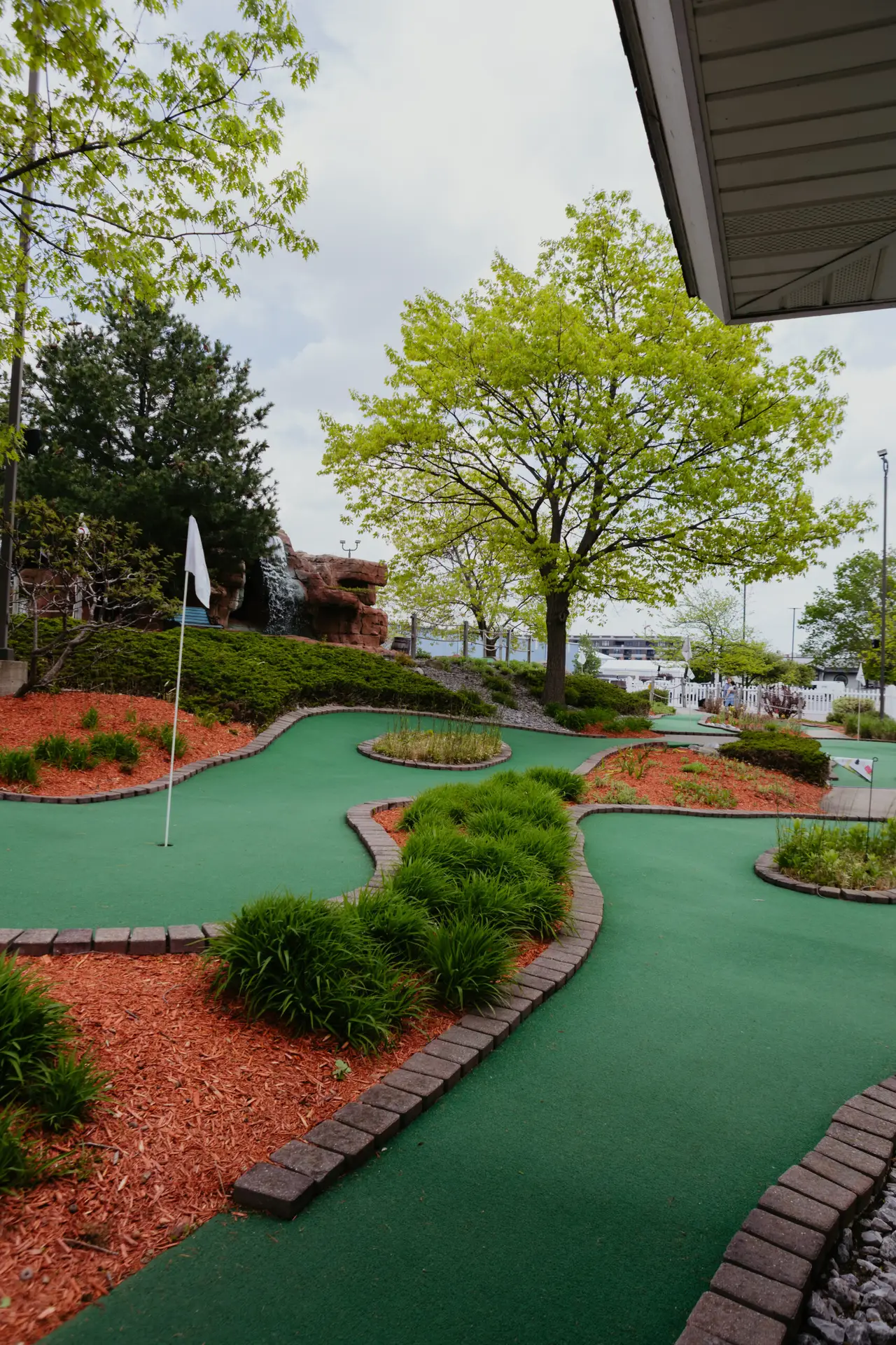 Scenic mini golf course at Buoy 18 in Bay City, Michigan, featuring winding greens, landscaped gardens, and a waterfall.