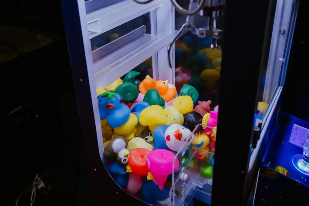 Claw machine filled with colorful rubber duck prizes inside the Buoy 18 arcade in Bay City, Michigan.
