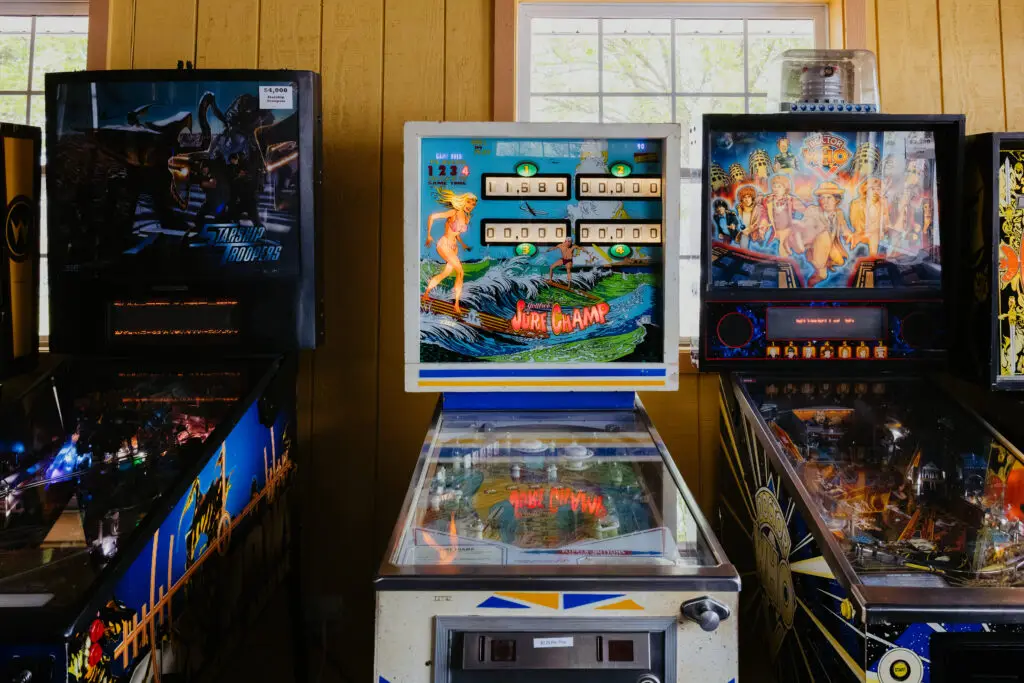 Classic pinball machines inside the Buoy 18 arcade in Bay City, Michigan, including Surf Champ and Doctor Who themed games.